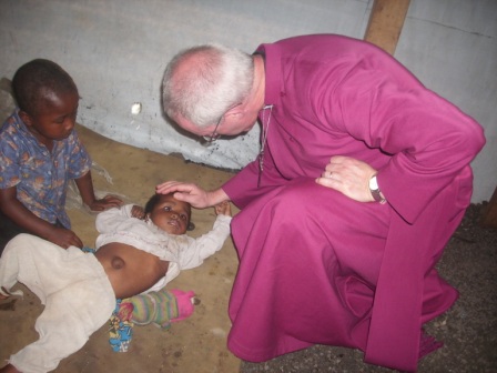 Justin-praying-for-lame-child-in-the-Goma-IDP-camp